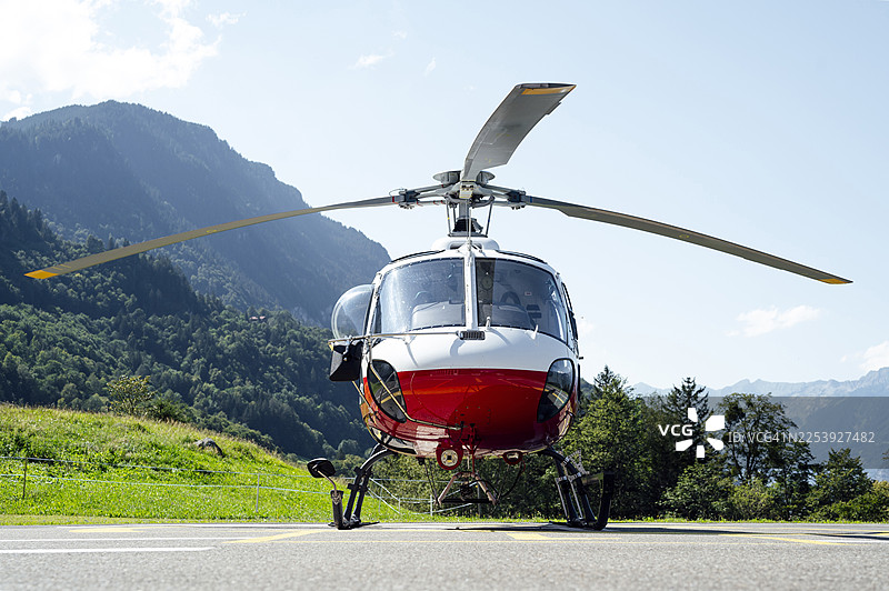 瑞士阿尔卑斯山直升机停机坪上的红色直升机图片素材