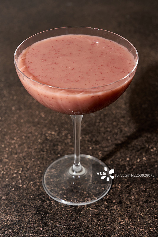 宽香槟杯中浓稠的浆果冰沙，置于花岗岩表面。健康无酒精混合饮品，适合均衡饮食。图片素材