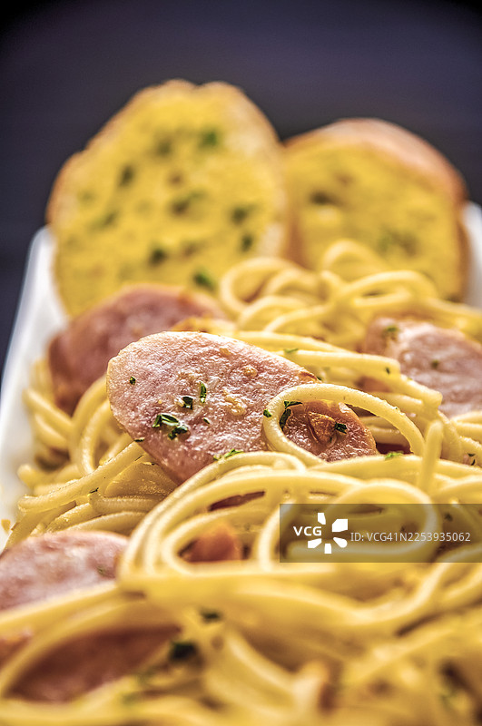 金蒜片和切碎香草的香肠意面特写图片素材