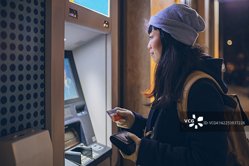 女子夜晚在ATM机取款图片素材
