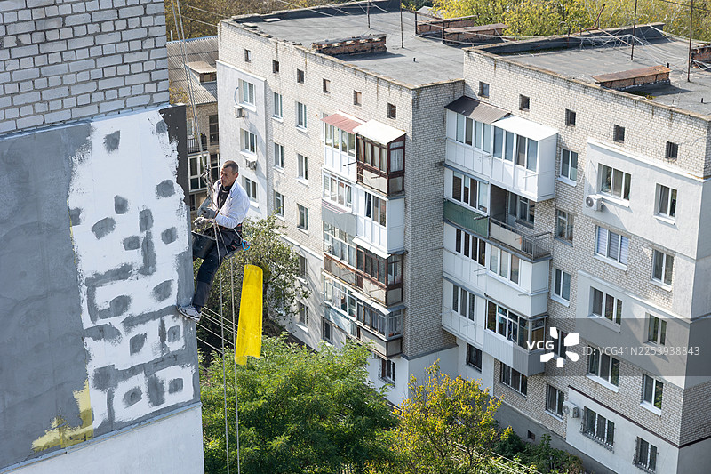 建筑工人在高处为房屋外墙保温。图片素材
