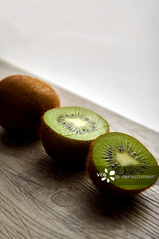 木质表面上三个猕猴桃的特写图片素材