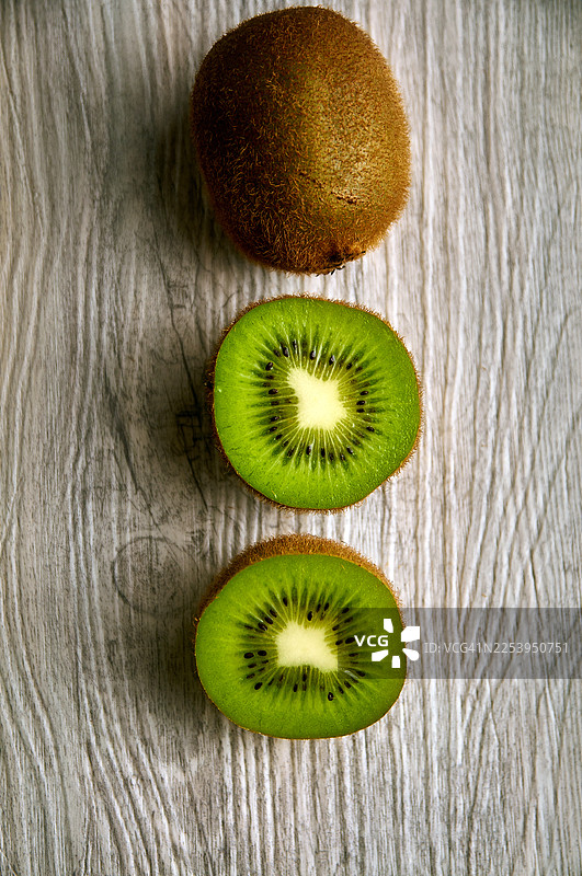 浅灰色木质表面上的猕猴桃俯视图图片素材
