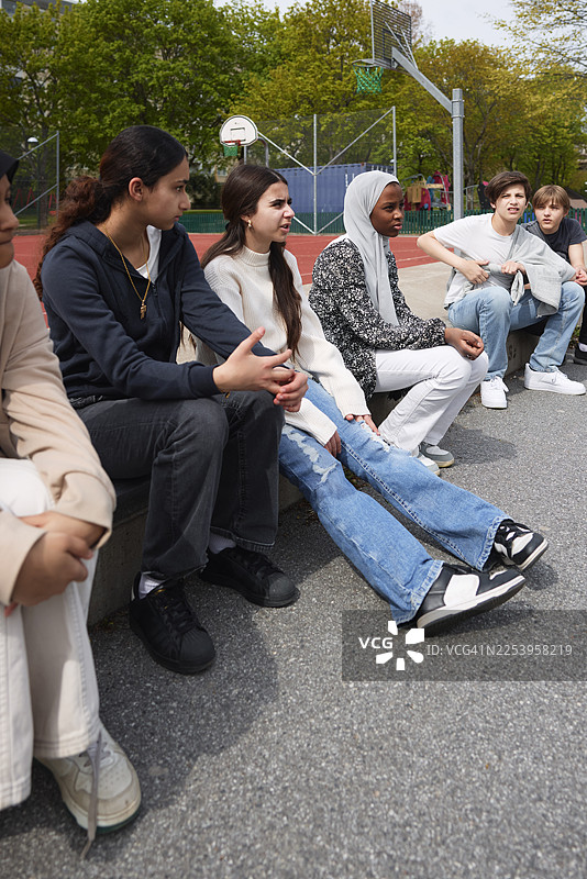 一群学生坐在校园里互相交谈图片素材