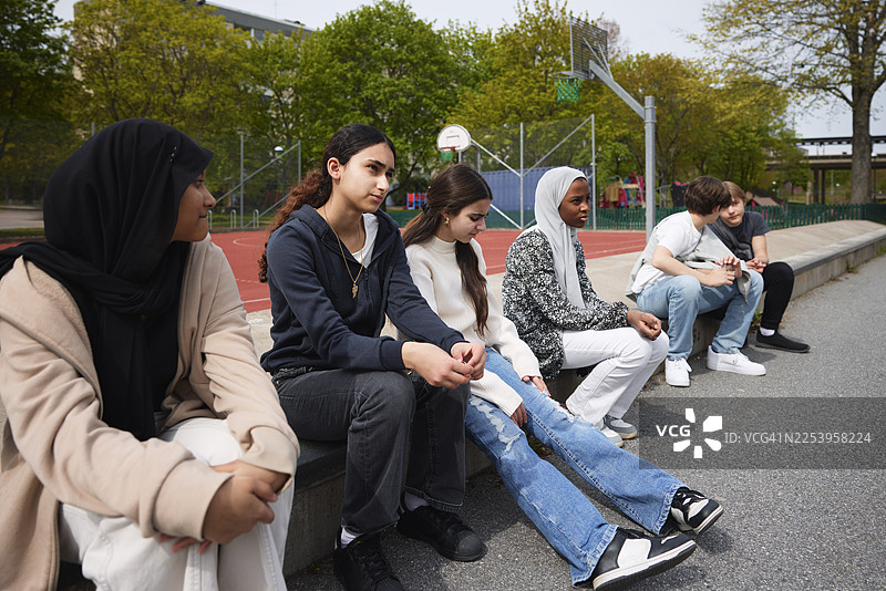 一群朋友坐在校园的长椅上图片素材