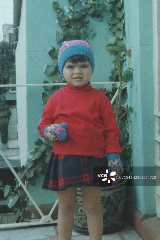 1960年代拍摄：一个小女孩在家里的后院看着镜头摆拍图片素材