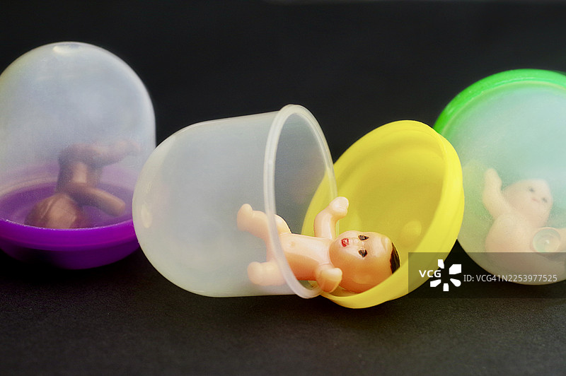 彩色塑料扭蛋机胶囊里的玩具婴儿公仔图片素材