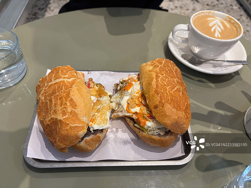 墨西哥风味吉拉基拉玉米片三明治配煎蛋，咖啡桌上的澳式白咖啡图片素材