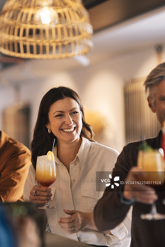 快乐的女人在酒吧的鸡尾酒派对上与朋友们一起玩乐图片素材