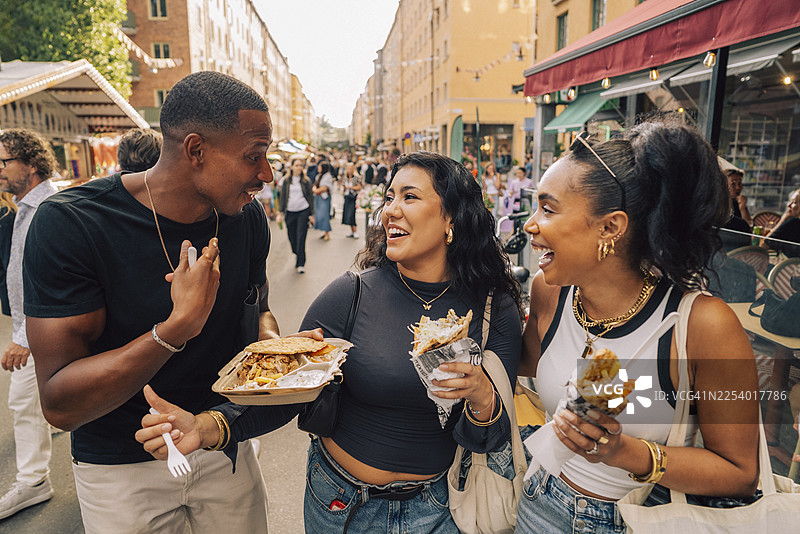 无忧无虑的多元种族男女朋友们一起享用街头小吃图片素材