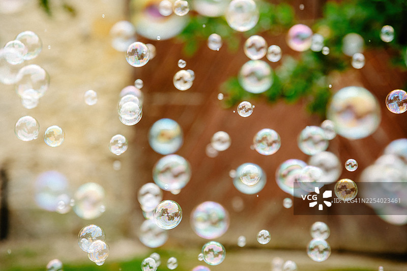 夏日阳光下闪耀的肥皂泡，明亮自然光中的梦幻彩虹倒影图片素材