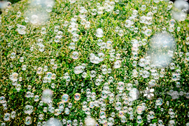 夏日阳光下闪耀的肥皂泡，明亮自然光中的梦幻彩虹倒影图片素材