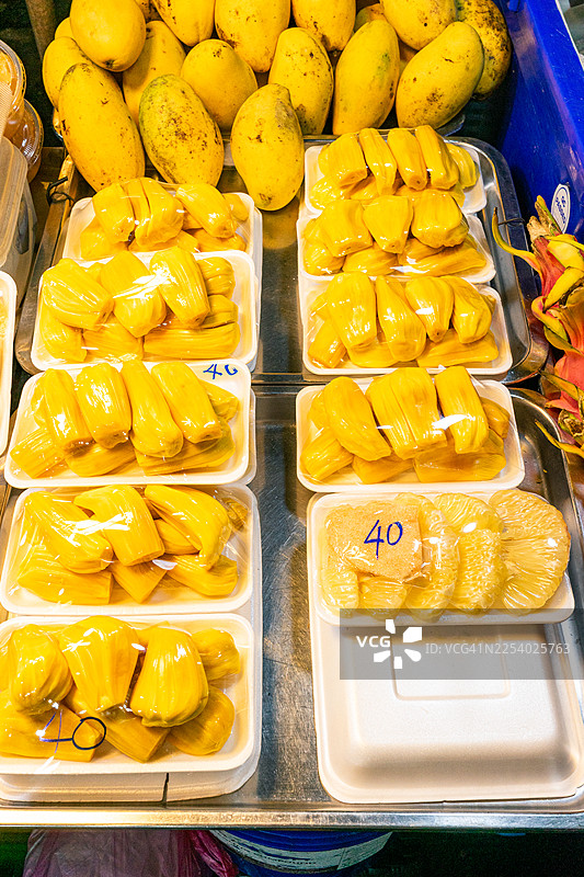 泰国充满活力的街头食品市场里新鲜包装的菠萝蜜和柚子出售，提供美味的热带水果零食图片素材