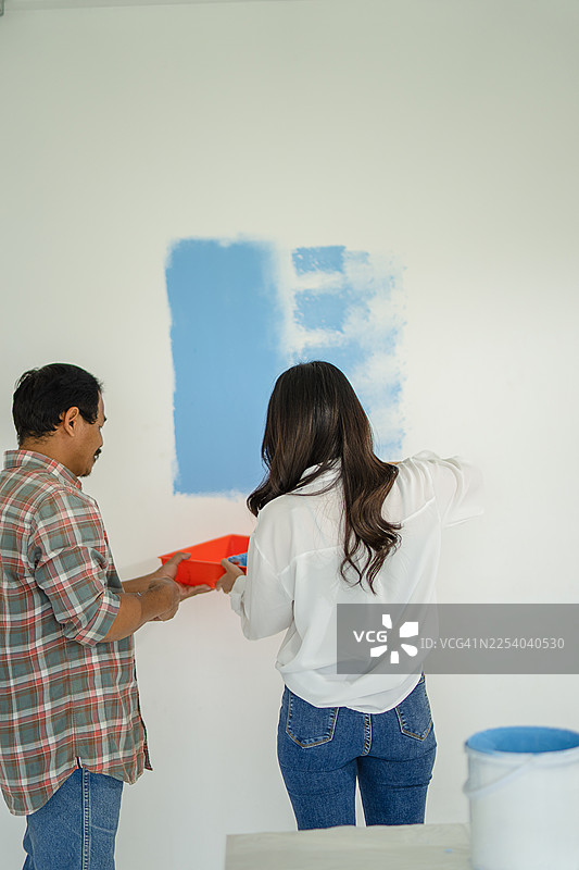 画家正在粉刷房屋的墙壁。图片素材