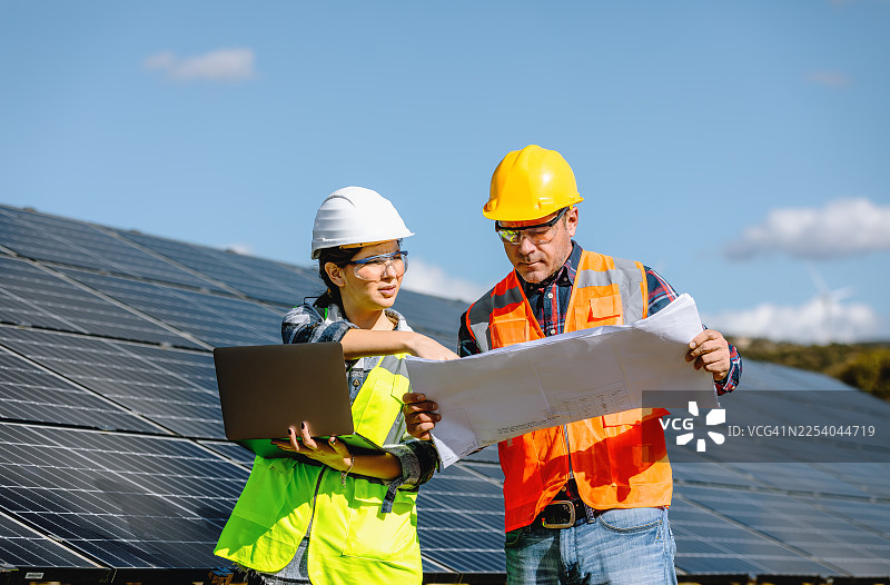 工程师们在农场上使用太阳能电池板和清洁电力工作图片素材