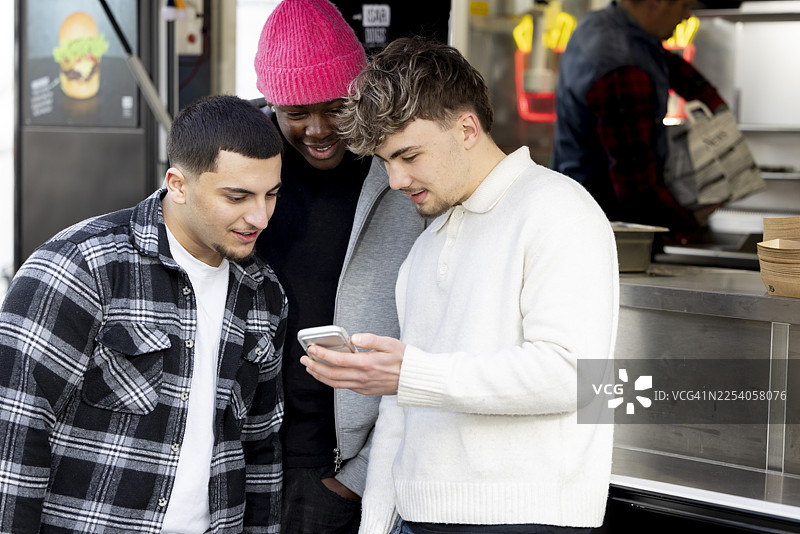 一群不同肤色的年轻学生在大学里，在餐车前休息，享受在一起的时光。图片素材