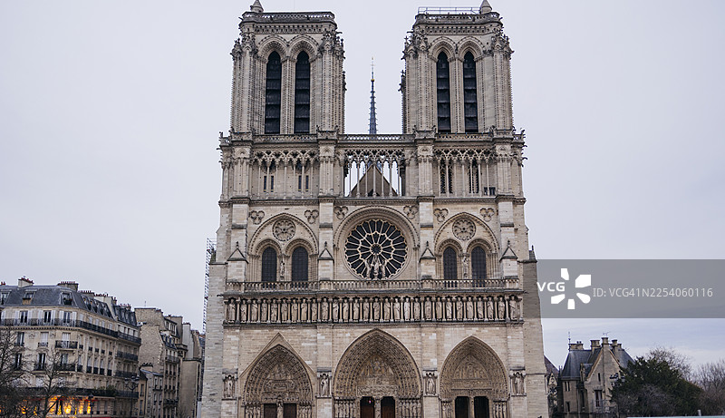巴黎圣母院大教堂的正面，背景是灰色的天空图片素材