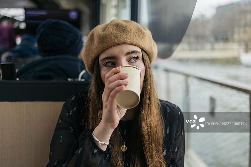 年轻女子在旅途中边喝咖啡边沉思图片素材