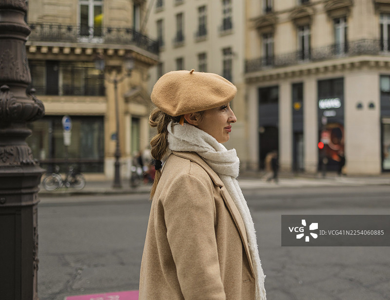 时尚女子头戴贝雷帽，身穿外套漫步巴黎图片素材