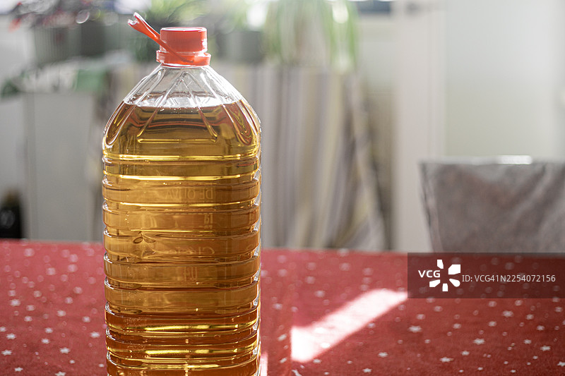 一张放在桌上的5升塑料橄榄油瓶，强调其容量、实用性和日常用途。图片素材