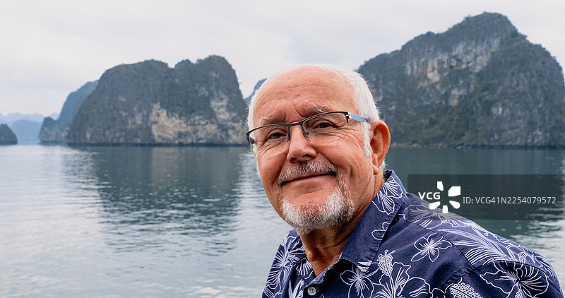 老年游客在下龙湾水域享受宁静的假期图片素材