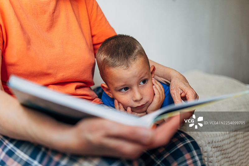 奶奶给好奇的孩子读睡前故事图片素材