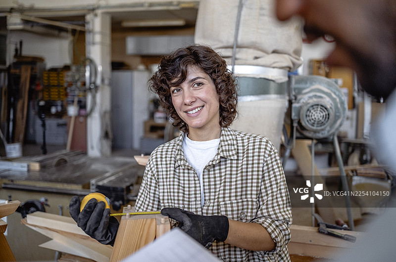不同性别和种族的木工师傅在木工房里协作图片素材