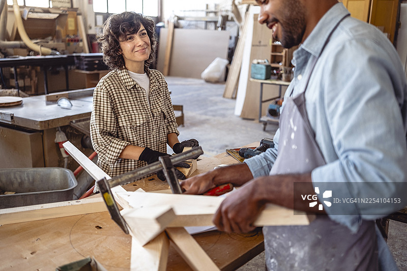 白种女性和多民族男性木工在明亮的工坊里一起工作图片素材