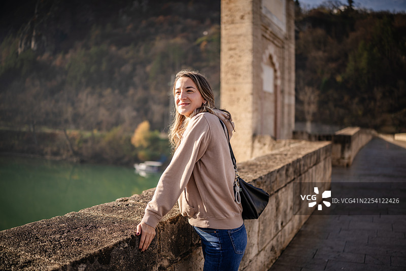 一位年轻女子在波斯尼亚和黑塞哥维那的维谢格拉德，在探索该地区时，在河边享受户外时光图片素材