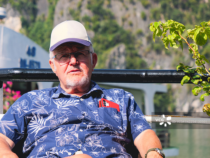 快乐或不快乐的退休老人，在下龙湾拥抱旅行图片素材