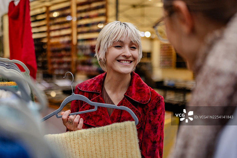 柏林繁忙的市场里，成年人正在购物，他们微笑着，在充满活力的日子里享受着购物体验。图片素材