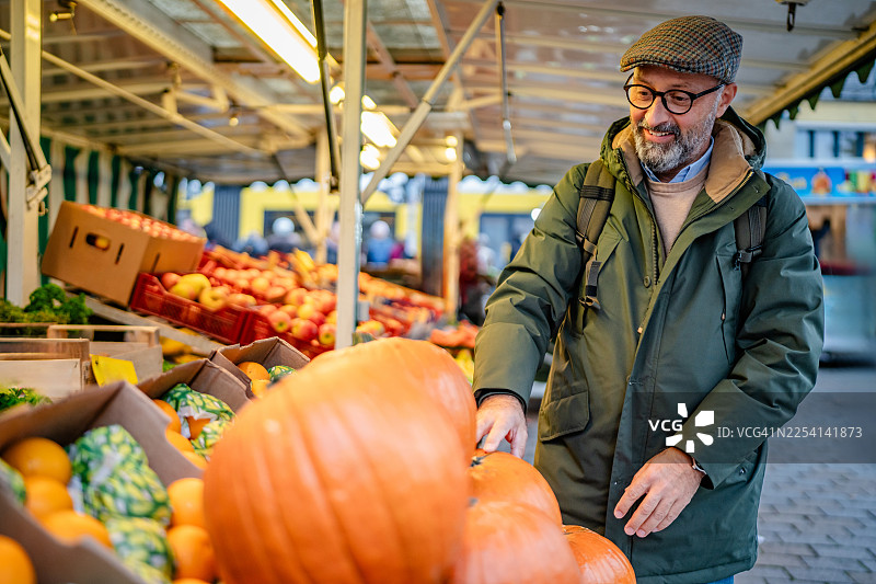 人们在柏林的市场购物，浏览各种水果和蔬菜进行购买。图片素材