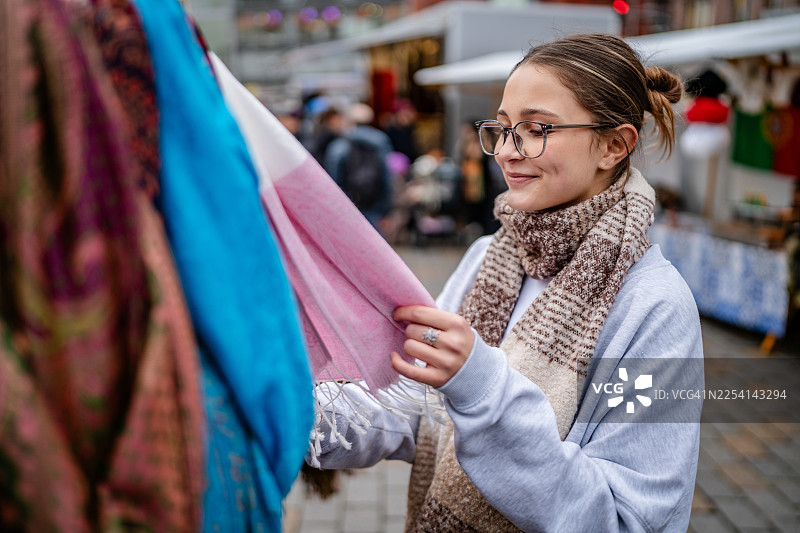 白天在柏林热闹的市场购买围巾，快乐的成年人享受着时光图片素材