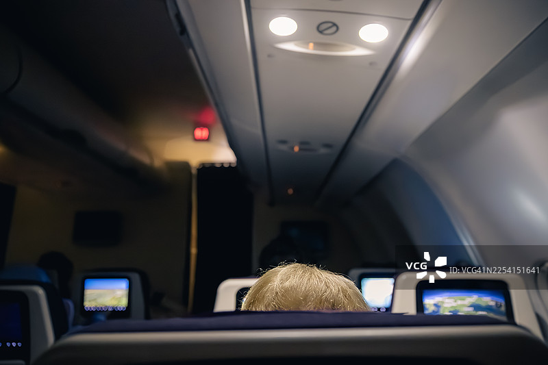 夜间航班中，一位年长女性从飞机后方看出去图片素材