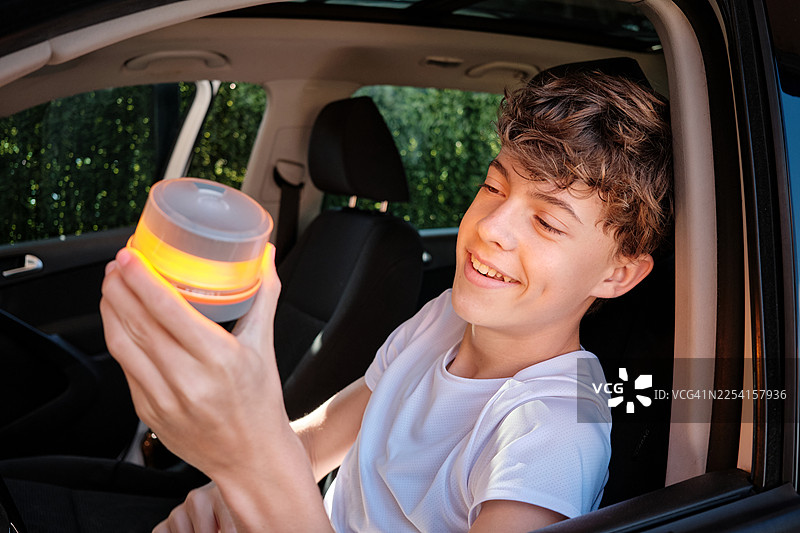 男孩在车内手持V16警示灯以确保行车安全图片素材