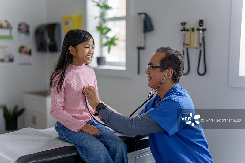 亚洲医生在诊所为快乐的小女孩进行体检图片素材