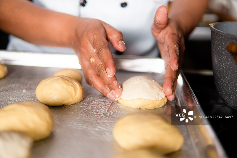 厨师正用手准备制作甜点糕点的面团球图片素材