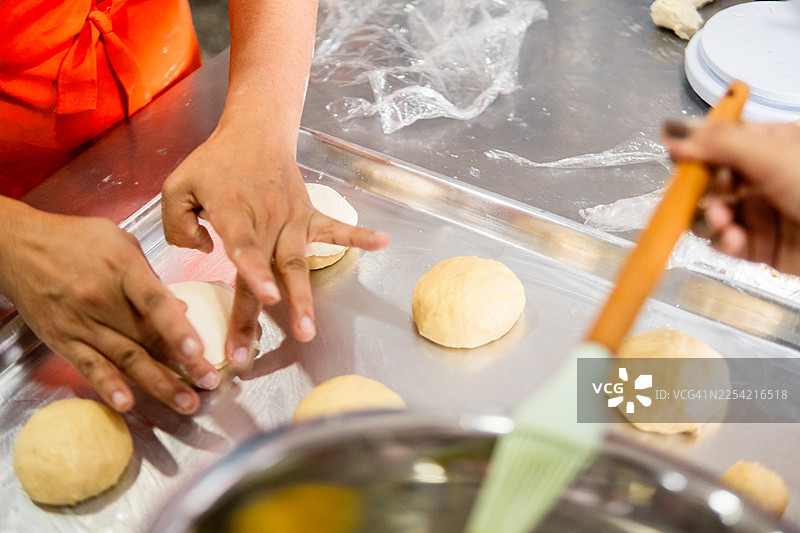 用手在烤盘上制作面团准备烘焙糕点图片素材