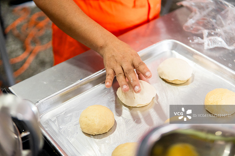 手将面团球放在金属烤盘上图片素材
