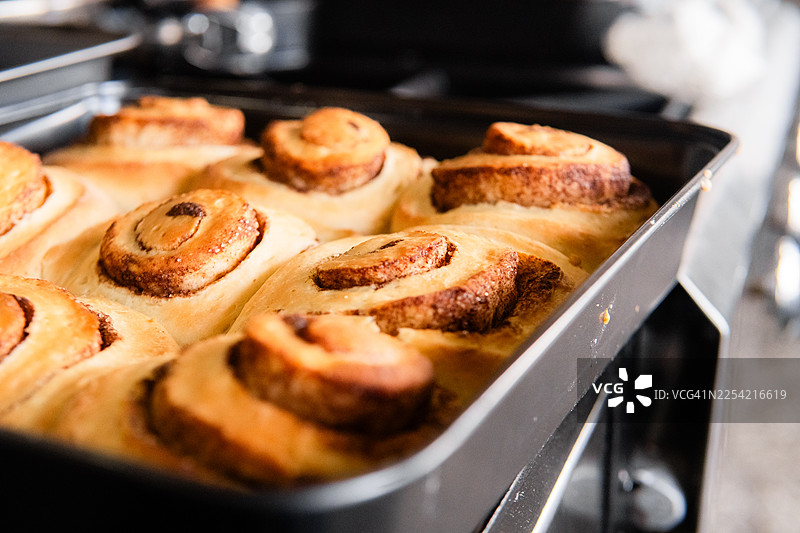 烤箱刚出炉的肉桂卷在烤盘中烘烤图片素材