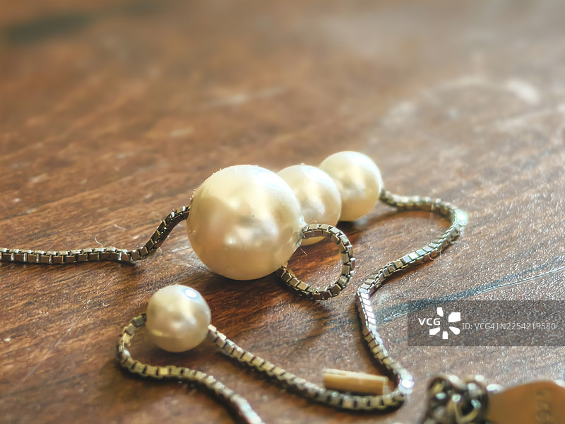 木质背景上金色珍珠项链的细节图片素材