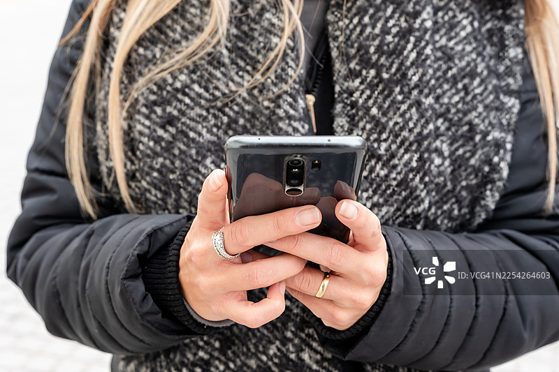 女子手持智能手机浏览社交媒体应用图片素材
