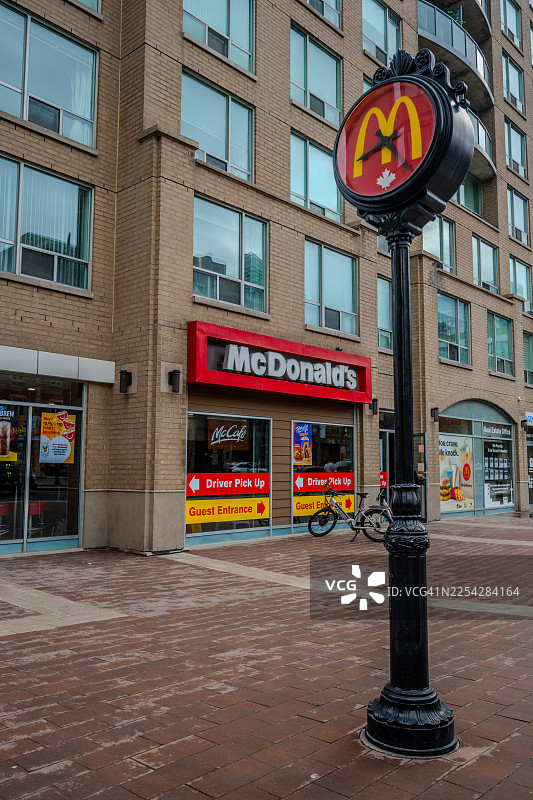 麦当劳餐厅，门前有街钟和公寓楼图片素材