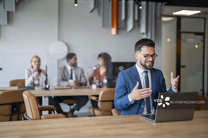 商务人士在进行视频会议，背景中有同事图片素材