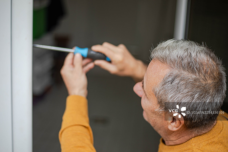 一位工匠正在维修门。图片素材
