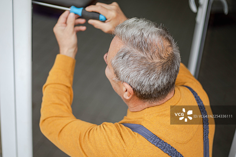 一位工匠正在维修一扇门。图片素材