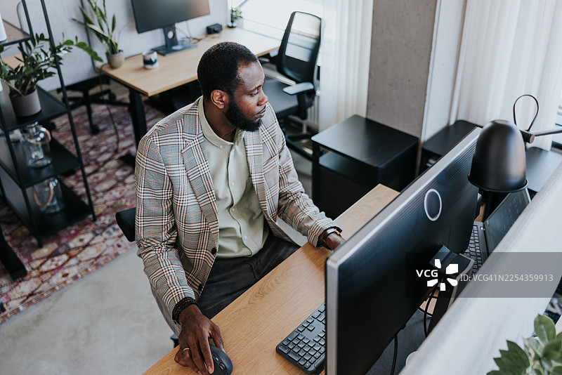 职业男士在现代办公桌前使用电脑图片素材