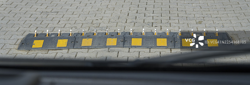 铺砌路面上的带黄色标记的地面障碍物，带有路面尖刺的单行道速度问题，钢制路面尖刺，从错误的方向碾过会损坏轮胎，格鲁吉亚姆茨赫塔-姆季阿涅季地区图片素材