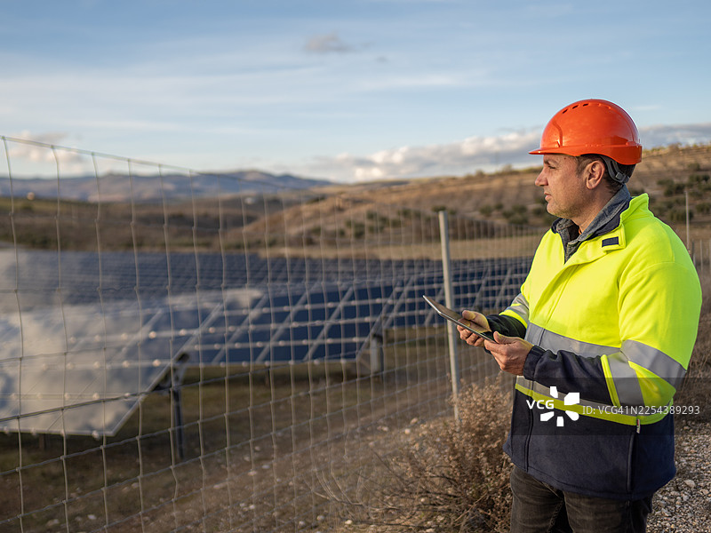 工程师使用数字平板电脑检查太阳能发电场图片素材
