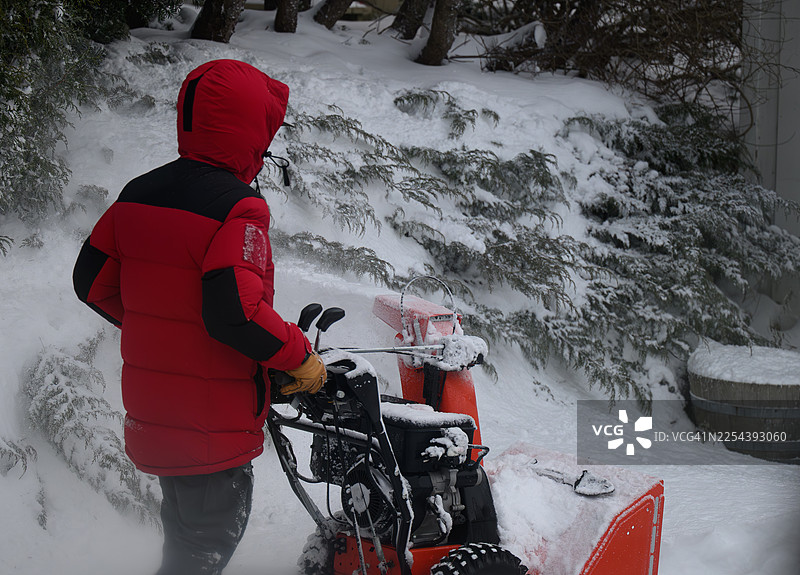 虽然有了吹雪机除雪看起来很容易，但它仍然是一项艰苦的工作图片素材